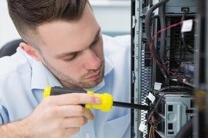 Technician using a screwdriver to work inside a computer.