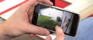 Person viewing security camera footage on a smartphone.