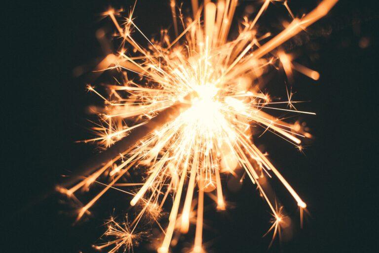 Close-up of a glowing sparkler against a dark background, symbolizing new beginnings with smart home systems in the New Year.
