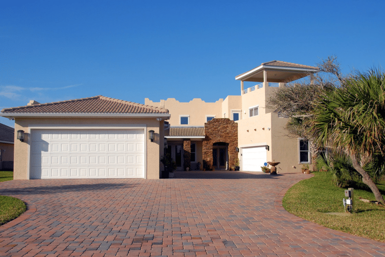 Modern luxury home with a wide driveway, showcasing the convenience of smart home systems.
