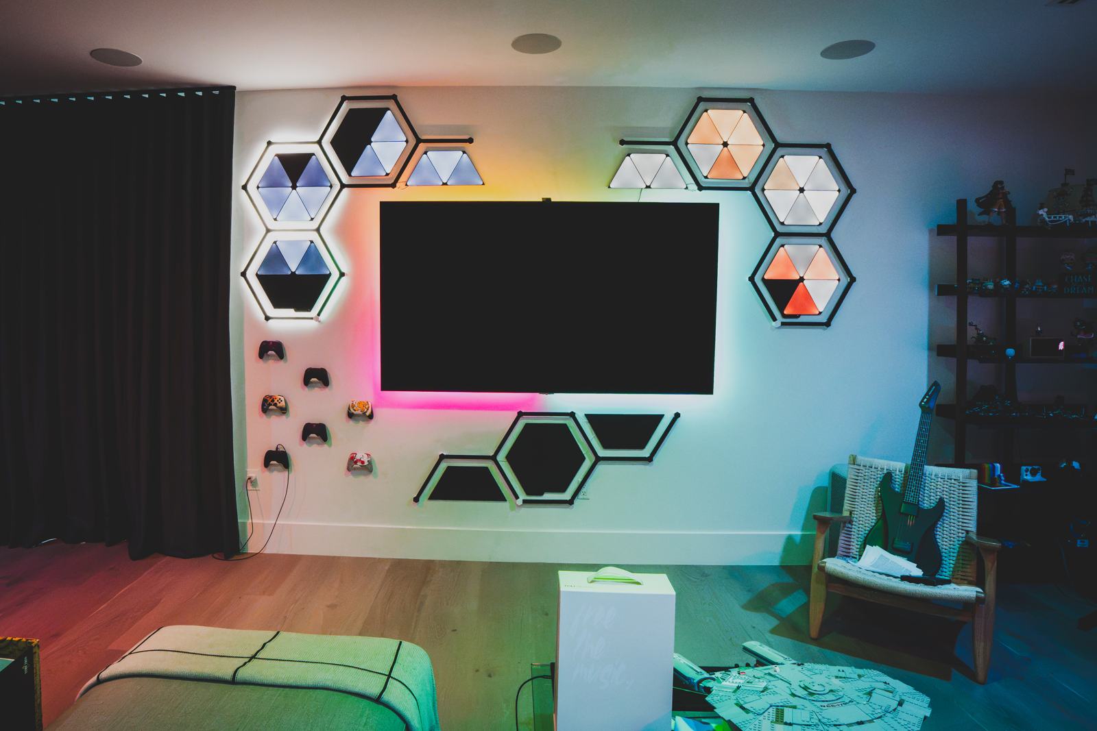 Game room with a wall-mounted television framed by colored hexagon light panels