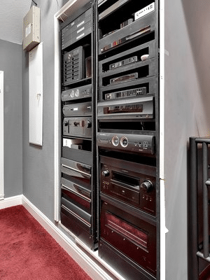 Built-in wall rack filled with audio and video equipment in a home theater or smart home setup.