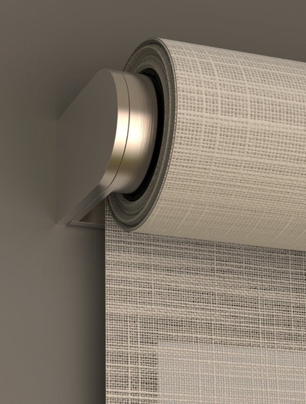 Close-up of a modern roller shade with a textured light-filtering fabric and sleek metal housing.