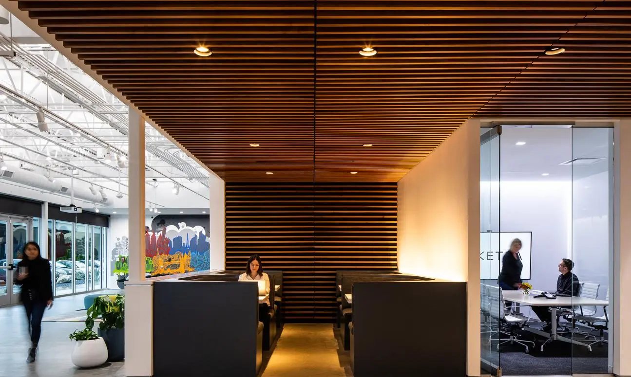 Wood-slat ceiling lobby at Ketra headquarters with a mural beyond glass