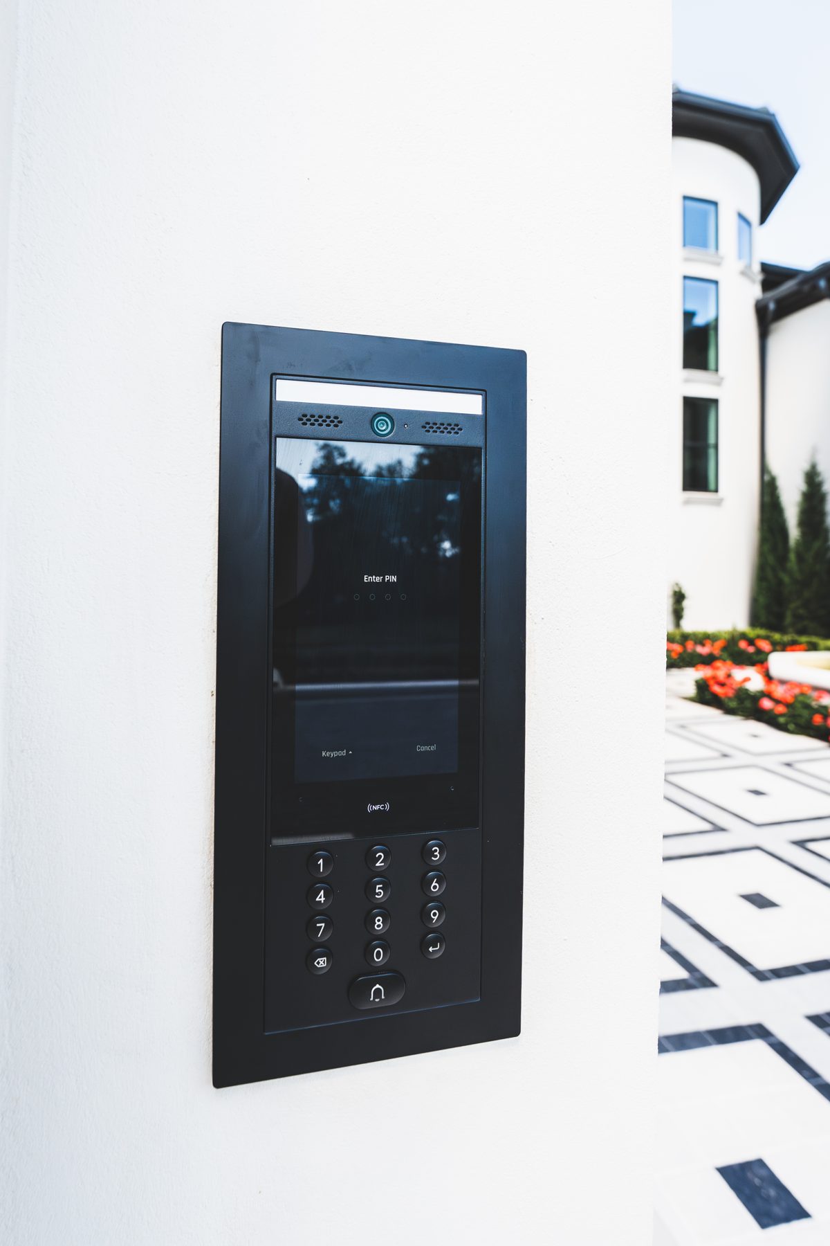 Video intercom with keypad mounted on a white wall